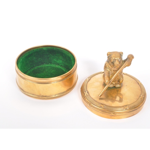 232 - An early 20th Century brass circular jewellery box / casket with lidded pot having figure of bear to... 
