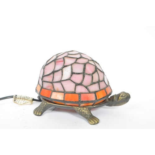 243 - A 20th century Tiffany manner glass and metal tortoise table / desk lamp. The lamp having a cast met... 