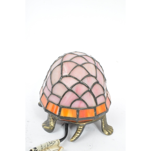 243 - A 20th century Tiffany manner glass and metal tortoise table / desk lamp. The lamp having a cast met... 