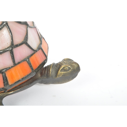 243 - A 20th century Tiffany manner glass and metal tortoise table / desk lamp. The lamp having a cast met... 