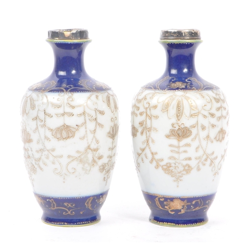 25 - A pair of Japanese china vases having white ground with dark blue borders and foliate decoration, wi... 