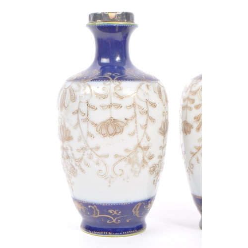 25 - A pair of Japanese china vases having white ground with dark blue borders and foliate decoration, wi... 