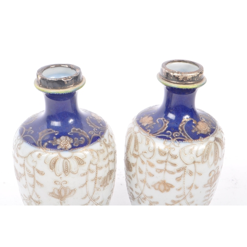 25 - A pair of Japanese china vases having white ground with dark blue borders and foliate decoration, wi... 