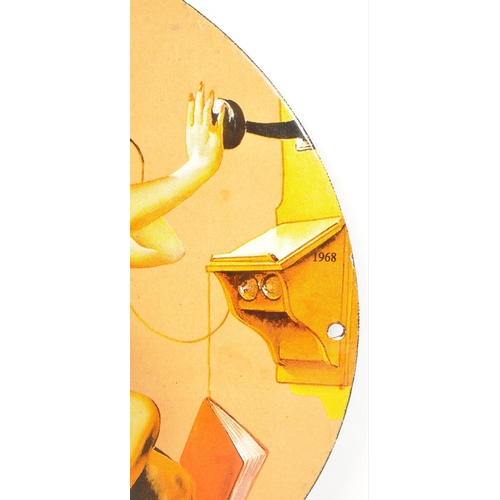263 - An enamel sign of circular form, picturing a woman sat on a stall holding a phone with the slogan 
