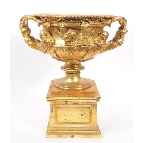 268 - A large gilt twin handled Warwick cup / vase / urn having gold relief Roman portrait imagery and kno... 