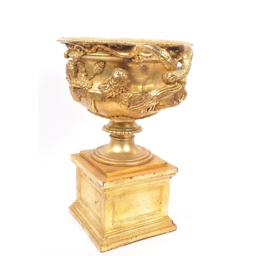 268 - A large gilt twin handled Warwick cup / vase / urn having gold relief Roman portrait imagery and kno... 