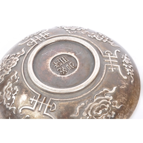 274 - A pair of Chinese Baitong metal plates. Each plate of rounded form with repousse dragon motifs to ce... 
