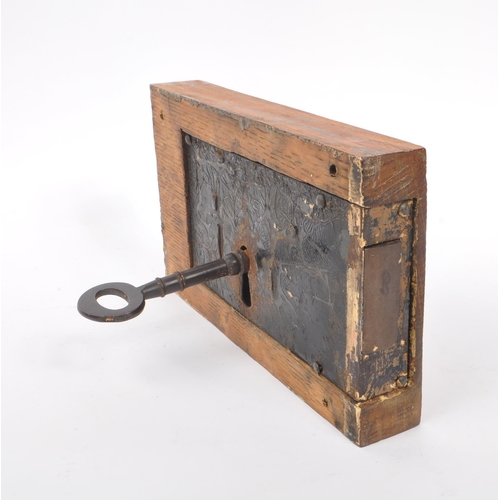 283 - A large 19th Century painted cast metal door lock having wooden block surround of rectangular form, ... 
