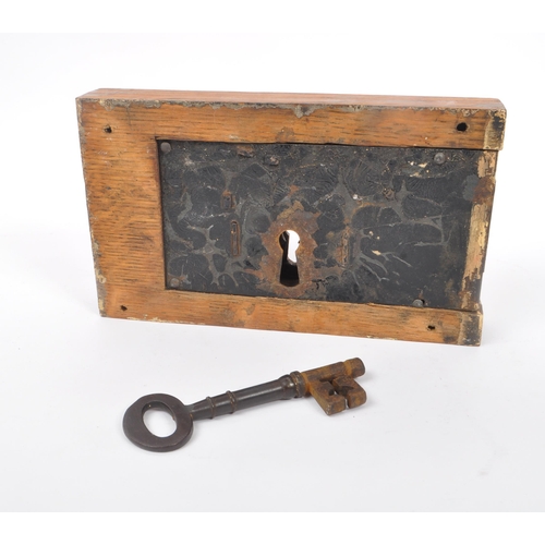 283 - A large 19th Century painted cast metal door lock having wooden block surround of rectangular form, ... 