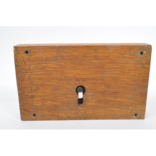 283 - A large 19th Century painted cast metal door lock having wooden block surround of rectangular form, ... 
