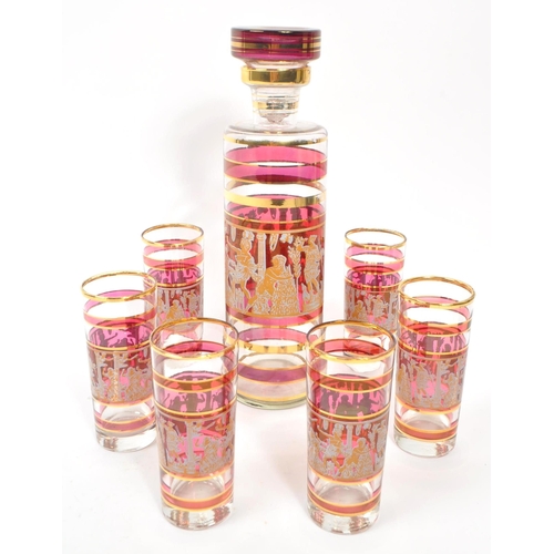 29 - A vintage 20th century circa 1970s gilt and cranberry drinking decanter and glass set. With circular... 