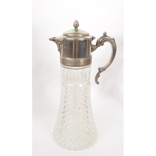293 - A 20th Century claret jug having cut glass body and silver plated top with flourishes to handle. Tog... 