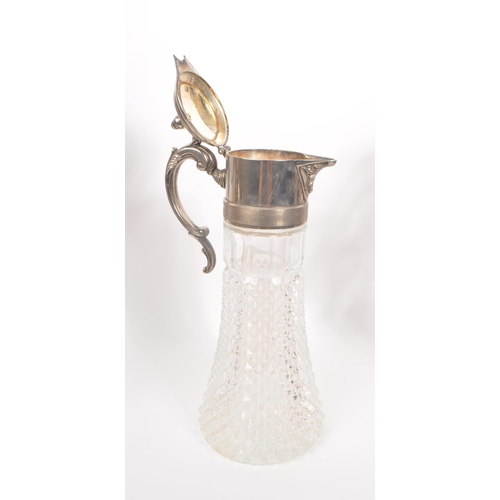 293 - A 20th Century claret jug having cut glass body and silver plated top with flourishes to handle. Tog... 