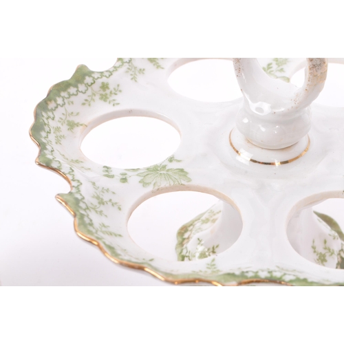 42 - An early 20th century circa 1900s porcelain oeufrier / egg cup stand. The stand having white ground,... 