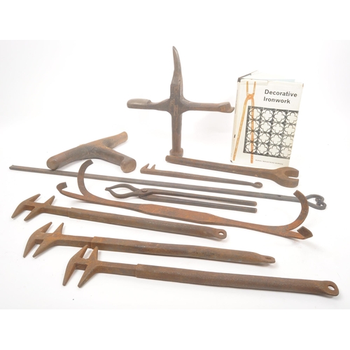 332 - A collection of 19th century Blacksmith's cast iron tools. Accompanying with decorative ironwork boo... 