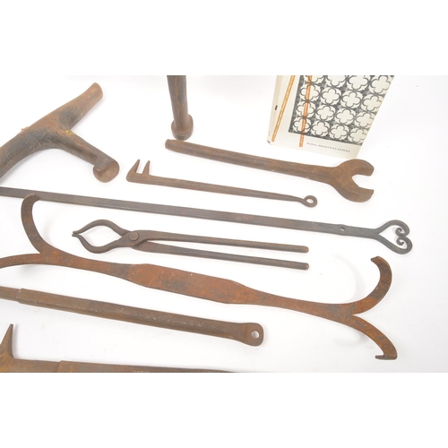 332 - A collection of 19th century Blacksmith's cast iron tools. Accompanying with decorative ironwork boo... 