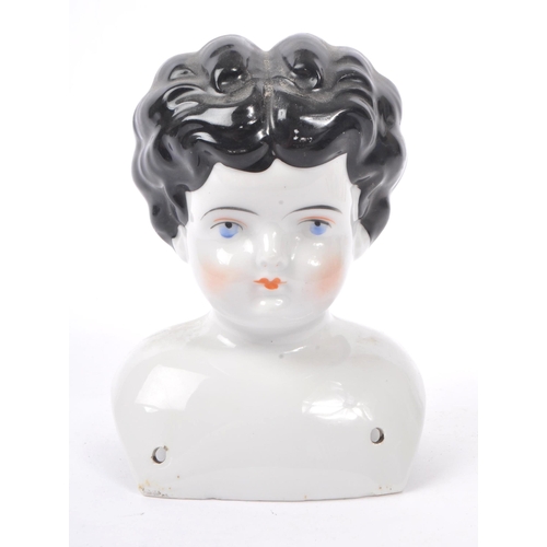 175 - An early 20th Century Art Deco china porcelain dolls head and shoulders, having hand painted feature... 