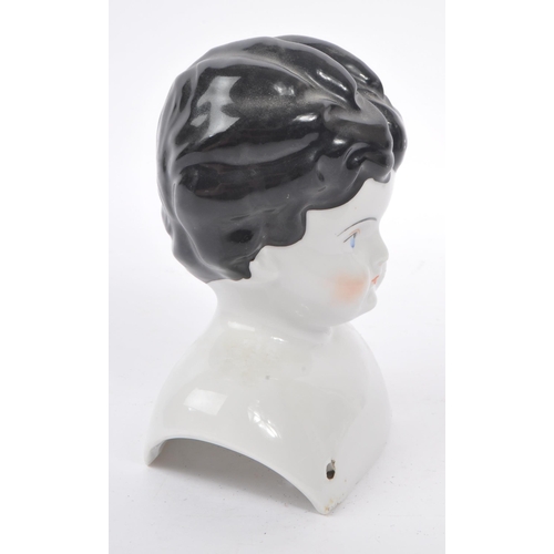 175 - An early 20th Century Art Deco china porcelain dolls head and shoulders, having hand painted feature... 