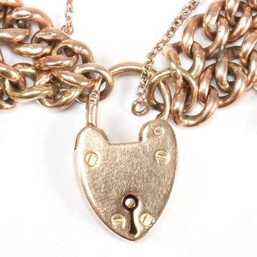 10 - A hallmarked 9ct gold charm bracelet with heart padlock clasp. The hallmarked 9ct gold double strand... 