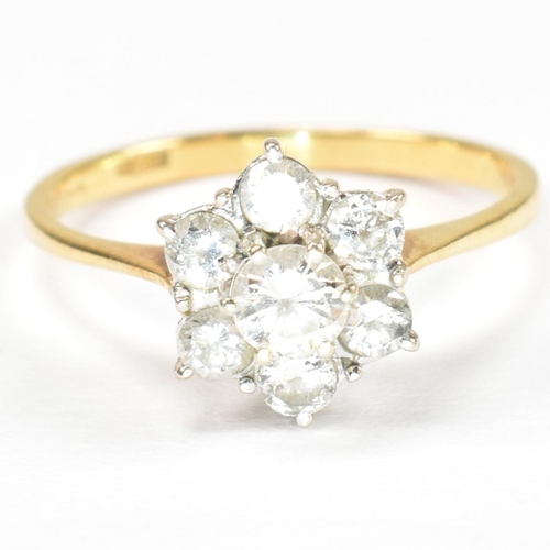 102 - An 18ct gold and diamond cluster ring. The ring set with a central round cut diamond surrounded by a... 