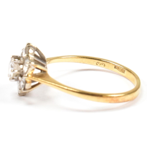 102 - An 18ct gold and diamond cluster ring. The ring set with a central round cut diamond surrounded by a... 