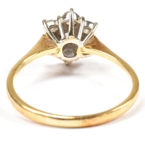 102 - An 18ct gold and diamond cluster ring. The ring set with a central round cut diamond surrounded by a... 