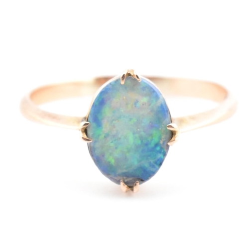 103 - A 9ct gold and opal triplet ring. The ring set with a double claw set opal triplet to tapered should... 