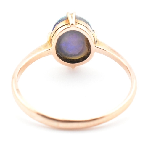 103 - A 9ct gold and opal triplet ring. The ring set with a double claw set opal triplet to tapered should... 