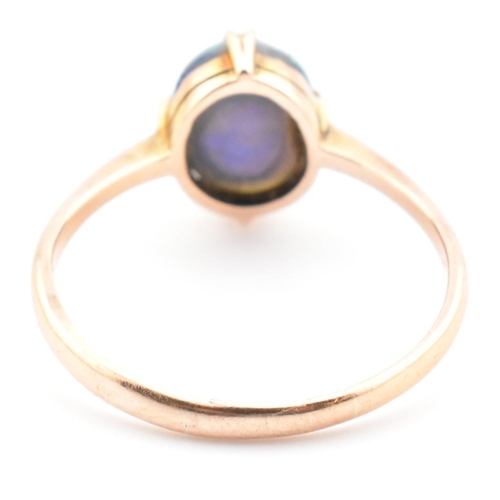 103 - A 9ct gold and opal triplet ring. The ring set with a double claw set opal triplet to tapered should... 