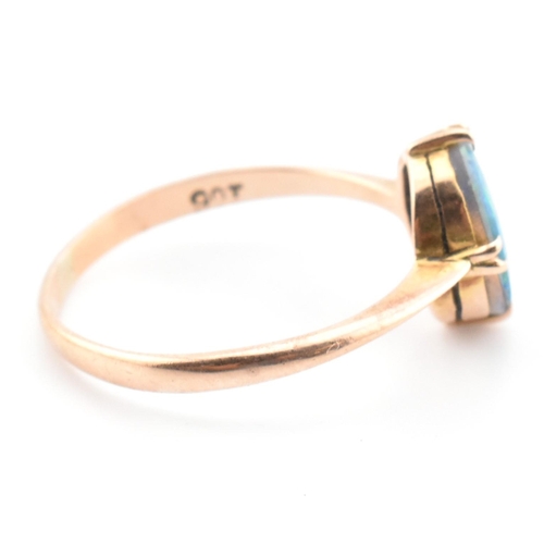 103 - A 9ct gold and opal triplet ring. The ring set with a double claw set opal triplet to tapered should... 