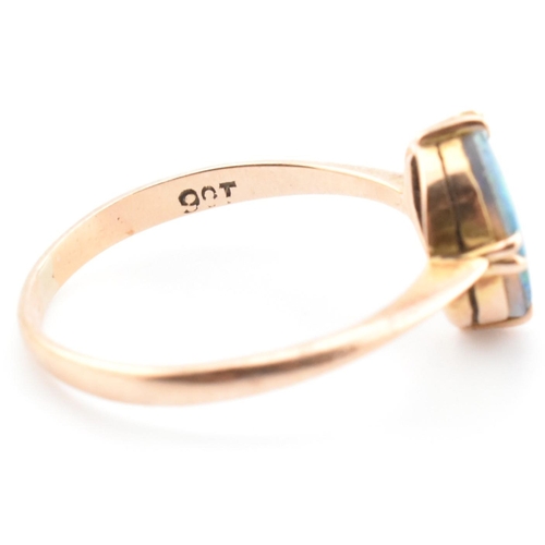 103 - A 9ct gold and opal triplet ring. The ring set with a double claw set opal triplet to tapered should... 