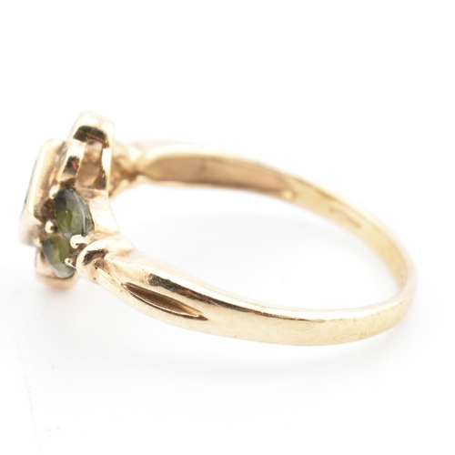 104 - A hallmarked 9ct gold, diamond and green sapphire cluster ring. The ring having a central bezel set ... 