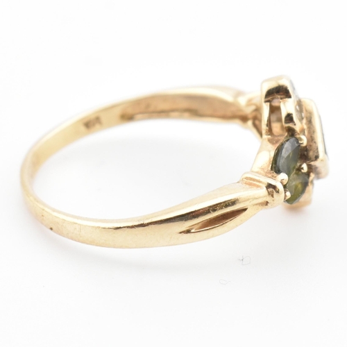 104 - A hallmarked 9ct gold, diamond and green sapphire cluster ring. The ring having a central bezel set ... 