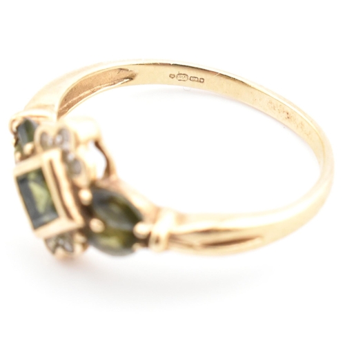 104 - A hallmarked 9ct gold, diamond and green sapphire cluster ring. The ring having a central bezel set ... 