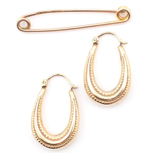 106 - A Victorian hallmarked 9ct gold safety pin together with a pair of 9ct gold hoop earrings. The lot t... 