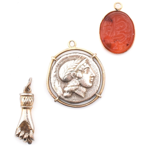 107 - Three necklace pendants. The pendants to include an oval carnelian pendant carved with stars and Ara... 