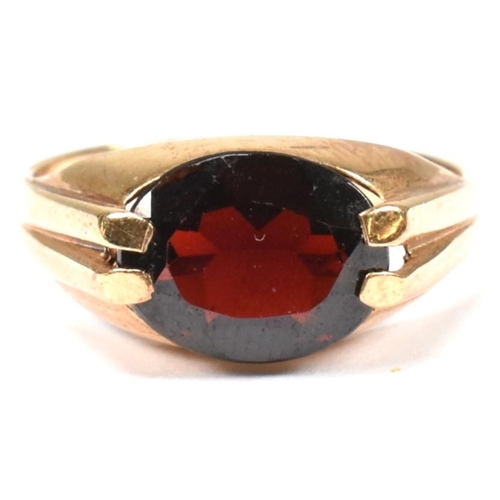 108 - A hallmarked 9ct gold and garnet ring. The 9ct gold ring having a double prong set east-west oval cu... 