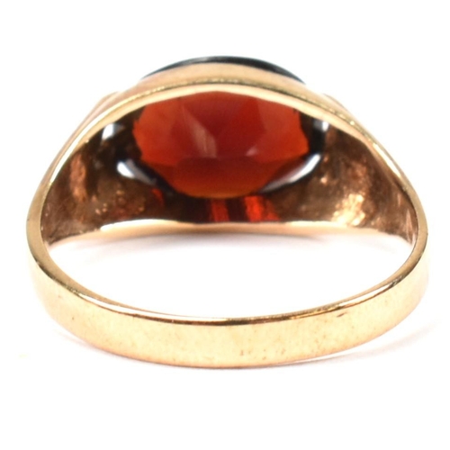 108 - A hallmarked 9ct gold and garnet ring. The 9ct gold ring having a double prong set east-west oval cu... 