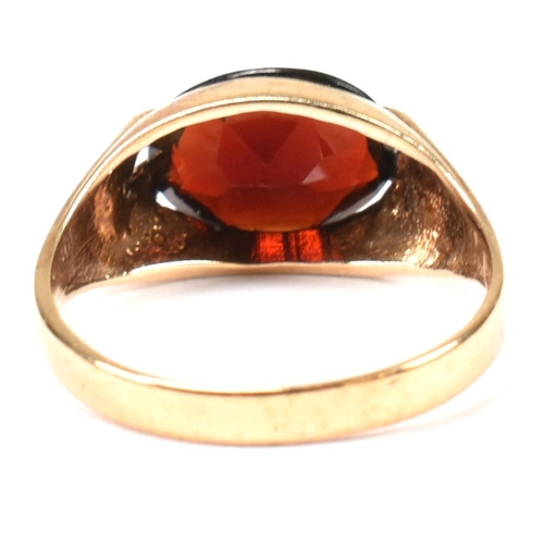 108 - A hallmarked 9ct gold and garnet ring. The 9ct gold ring having a double prong set east-west oval cu... 