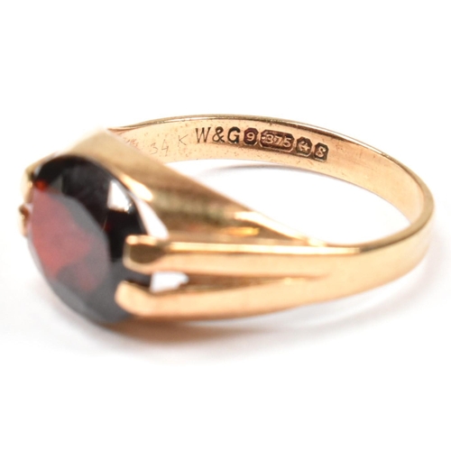 108 - A hallmarked 9ct gold and garnet ring. The 9ct gold ring having a double prong set east-west oval cu... 