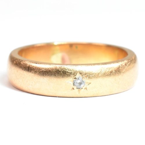 110 - A gold and paste band ring. The band ring having a star set round cut white paste stone. Unmarked ho... 