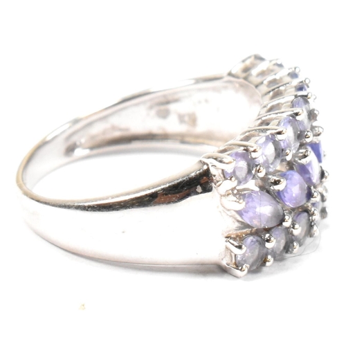 121 - A hallmarked 9ct white gold and purple stone cluster ring. The ring having central row of six marqui... 