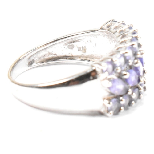 121 - A hallmarked 9ct white gold and purple stone cluster ring. The ring having central row of six marqui... 