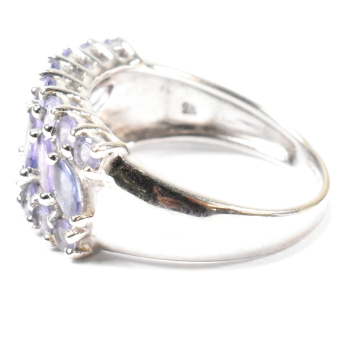 121 - A hallmarked 9ct white gold and purple stone cluster ring. The ring having central row of six marqui... 