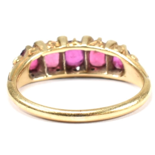 123 - A gold, red stone and diamond five stone ring. The ring having a mixture of mixed cut red stones inc... 