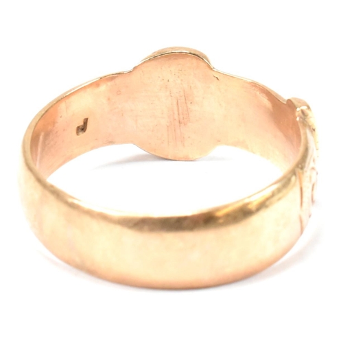 125 - A hallmarked 9ct gold buckle ring. The buckle ring having scrolling bright cut engraved decoration t... 