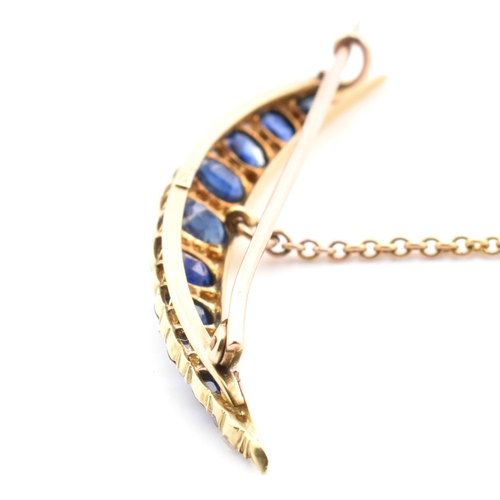 13 - An early 20th century gold, diamond and sapphire crescent brooch pin. The crescent brooch pin set wi... 