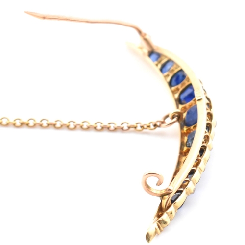 13 - An early 20th century gold, diamond and sapphire crescent brooch pin. The crescent brooch pin set wi... 