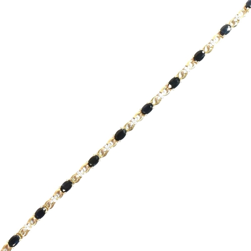 158 - A 9ct gold, sapphire and diamond line bracelet. The 9ct gold bracelet having eleven oval cut sapphir... 