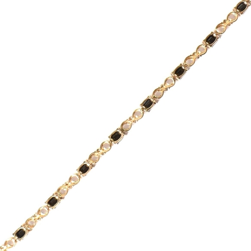 158 - A 9ct gold, sapphire and diamond line bracelet. The 9ct gold bracelet having eleven oval cut sapphir... 